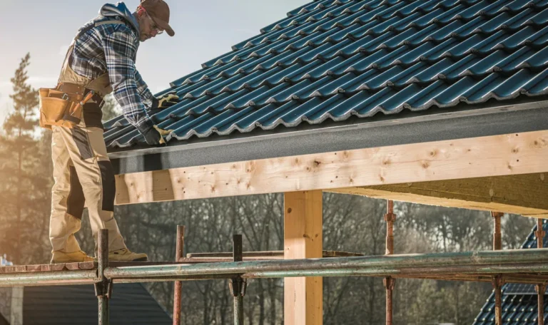 A builder installs a roof on a construction site under a clear blue sky, highlighting the importance of roof maintenance.